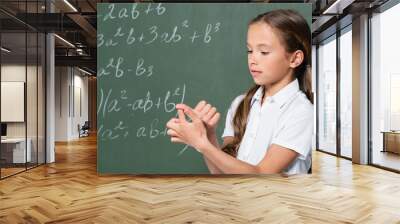 preteen schoolgirl counting on fingers near chalkboard with mathematic equations Wall mural