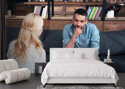 rear view of female counselor writing in clipboard and talking to male patient in office Wall mural