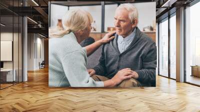 retired couple holding hands and looking at each other at home Wall mural