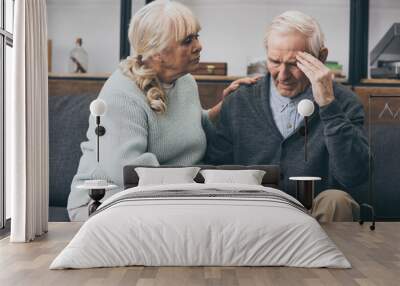 retired woman sitting near senior husband with headache Wall mural