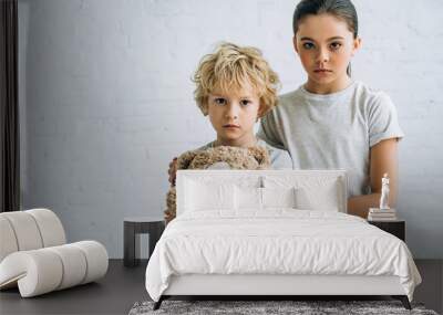 sad sister and brother with teddy bear at home Wall mural