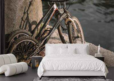 scenic view of two mountain bicycles and tourist tent on rocky cliff over river Wall mural