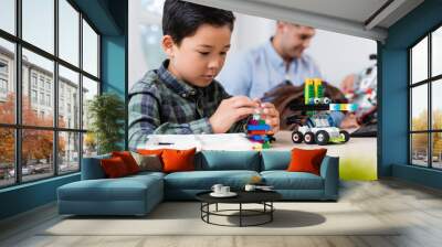 Selective focus of asian schoolboy with building blocks modeling robot near friend and teacher in school Wall mural