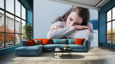 selective focus of beautiful sad woman hugging knees and looking away Wall mural