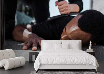 selective focus of detained african american man lying on ground near policeman with baton, racism concept Wall mural