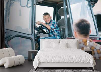 selective focus of father looking at happy son sitting in tractor Wall mural