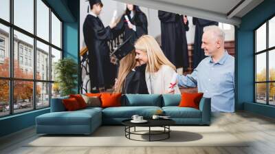 selective focus of girl in graduation cap hugging with mother near father Wall mural