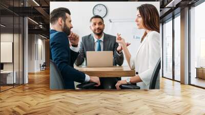 selective focus of investors in suits talking with advisor on background at workspace Wall mural