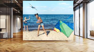 selective focus of multicultural friends with kites spending time on sandy beach together Wall mural