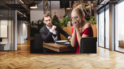 selective focus of offended woman crying near boyfriend in restaurant Wall mural