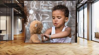 selective focus of poor african american boy playing with dirty teddy bear near child Wall mural