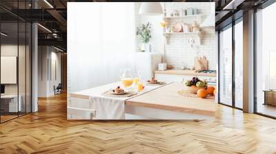 served table with pancakes, fruits and orange juice in kitchen Wall mural