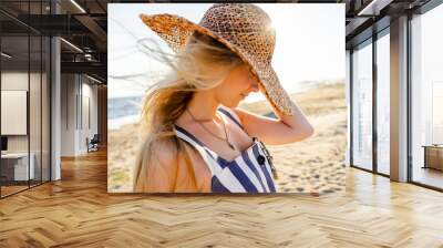 side view of attractive young woman in straw hat on sandy beach in Riga, Latvia Wall mural