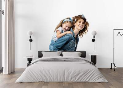 side view of laughing mother piggybacking daughter in denim outfit isolated on white Wall mural