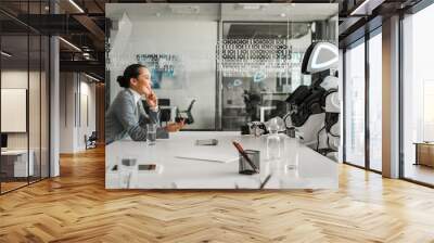 Side view of smiling Asian businesswoman talking to robot in conference hall Wall mural