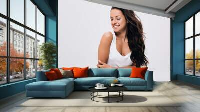 smiling brunette beautiful woman with crossed arms and long healthy and shiny hair isolated on grey Wall mural