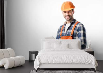 Smiling builder in orange overall and hard hat using digital tablet isolated on white Wall mural