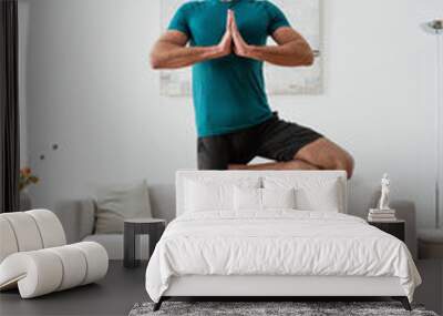 smiling man looking away while standing in one legged tree pose Wall mural