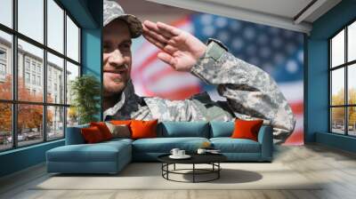 Smiling military man saluting with blurred American flag on background, banner Wall mural