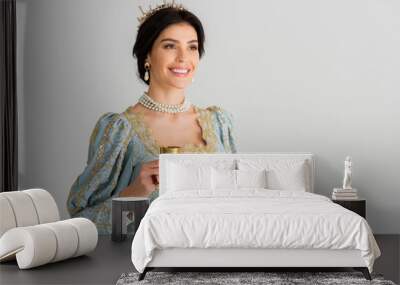 smiling queen with crown holding cup isolated on grey Wall mural