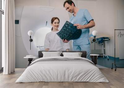 smiling radiologists showing x-ray results to happy attractive woman Wall mural