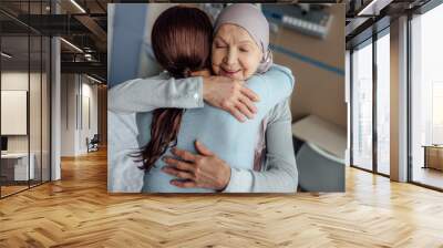 smiling senior woman in kerchief hugging daughter in hospital Wall mural