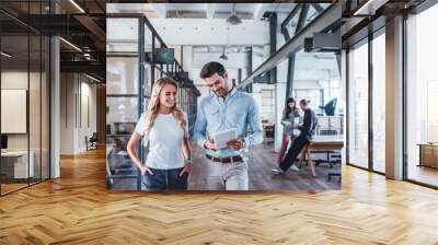 smiling young business colleagues using digital tablet at workspace Wall mural