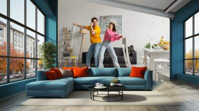 smiling young couple in casual clothes dancing in modern loft Wall mural