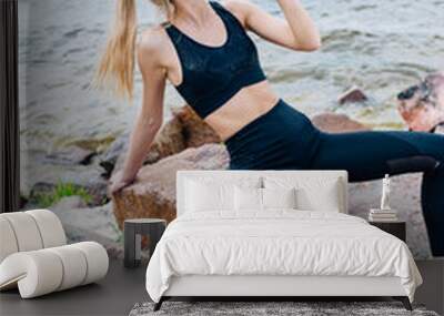 sportswoman with closed eyes holding sport bottle while drinking water near sea Wall mural