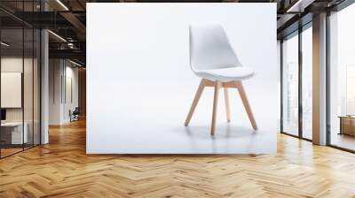 Studio shot of stylish chair with white top and light wooden legs standing on white Wall mural