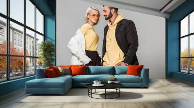 stylish couple of models in autumn outfits posing isolated on grey background Wall mural