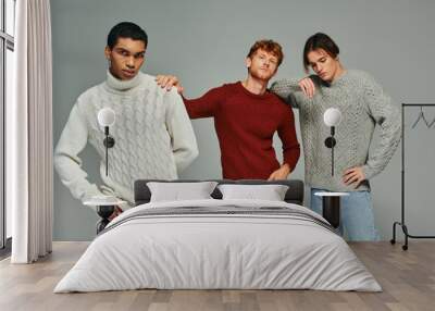 stylish interracial male models in vibrant casual sweaters posing on gray backdrop, men power Wall mural