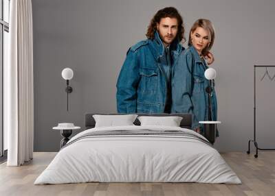 stylish man hugging woman in denim jacket isolated on grey Wall mural