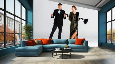 stylish man in suit and aristocratic woman holding hands while dancing on grey Wall mural