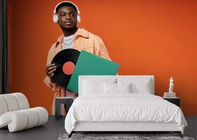 Stylish young Black man holding a vinyl record. Wall mural