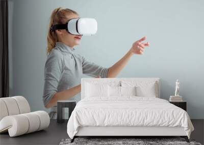 surprised woman gesturing while having virtual reality experience isolated on grey Wall mural