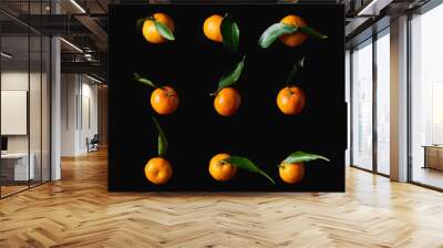 tasty orange tangerines with green leaves isolated on black Wall mural