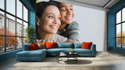 teenage african american girl with closed eyes embracing happy mom at home, banner Wall mural