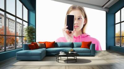 teenage girl in pink hoodie holding smartphone with blank screen in front of face isolated on white Wall mural