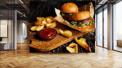 Tempting fast food diner with burgers and potatoes with sauce on cutting board Wall mural