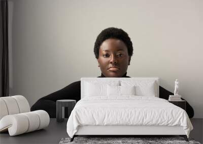 thoughtful african american woman in black turtleneck sitting at table isolated on grey Wall mural