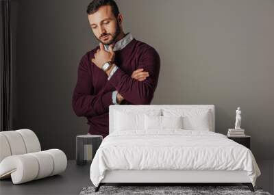 thoughtful handsome male model posing in burgundy sweater, isolated on grey Wall mural