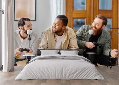 Three cheerful, interracial men in casual attire enjoying a gaming session around a table at home. Wall mural