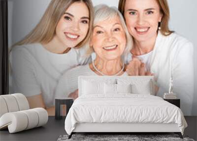 three generation of happy women smiling while looking at camera isolated on grey Wall mural