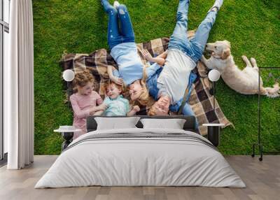 top view of happy young family with golden retriever dog resting on grass at picnic Wall mural