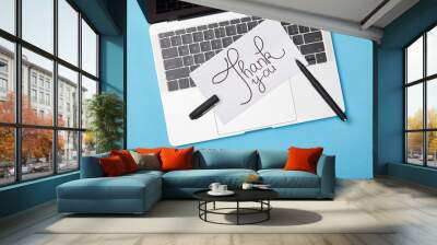 top view of laptop and card with thank you lettering and pen on blue background Wall mural