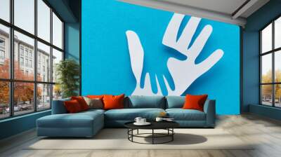 top view of paper cut parent and child hands on blue background, panoramic shot Wall mural