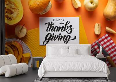 top view of pumpkin pie, ripe apples and happy thanksgiving card on orange background Wall mural