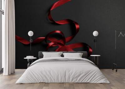 top view of red satin wavy ribbon on black background with copy space Wall mural