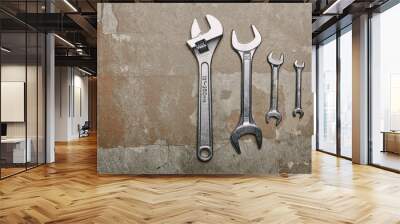 Top view of set of wrenches tools and one monkey wrench on the background of old  surface Wall mural